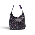 A black hobo shoulder bag with a purple and Skeleton pumpkin pattern, featuring a matching purple strap and silver-tone hardware, shown against a plain white background.