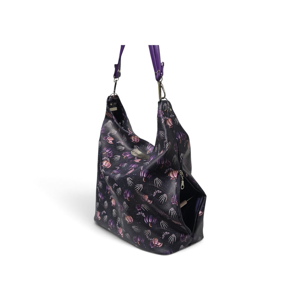A black hobo shoulder bag with a purple and pink jellyfish pattern, featuring a matching purple shoulder strap and silver-tone hardware, shown on a white background.