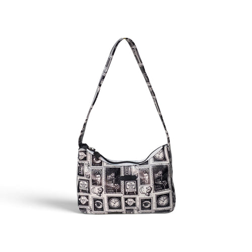 A black and white patterned hobo shoulder bag with a long strap, featuring a collage of vintage-style portrait frames and monochrome illustrations on a clean white background.