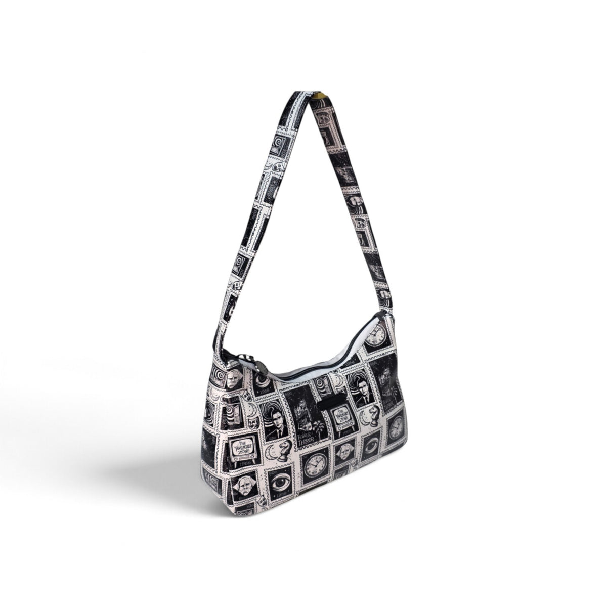 A black and white patterned shoulder bag with a single strap, featuring a collage of vintage-style postcard designs, shown on a white background.