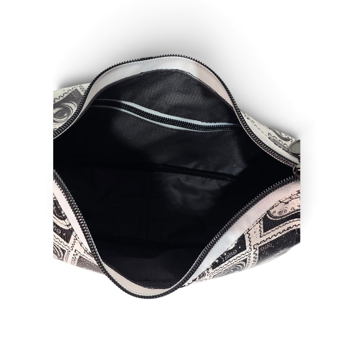 An overhead view of an open cosmetic pouch or small bag, showing a grey interior lining and a black-and-white patterned exterior, set against a plain white background.