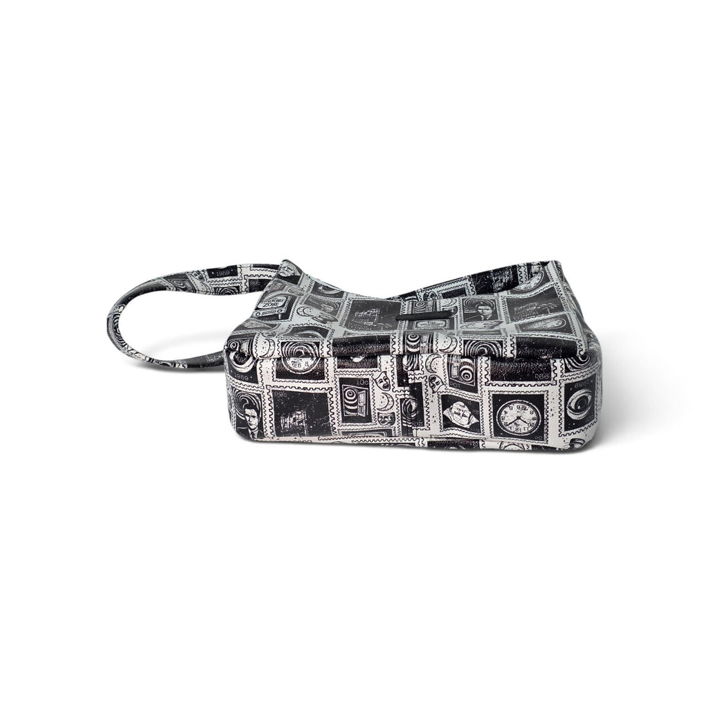 A small rectangular handbag with a black and white collage print of vintage postcards and illustrations, featuring a matching top handle, shown on a plain white background.