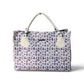 A structured tote bag with a white base covered in a repeating purple and blue pattern of small illustrated figures. It has light gray handles and off-white leather-like front tab accents, photographed on a clean white background.