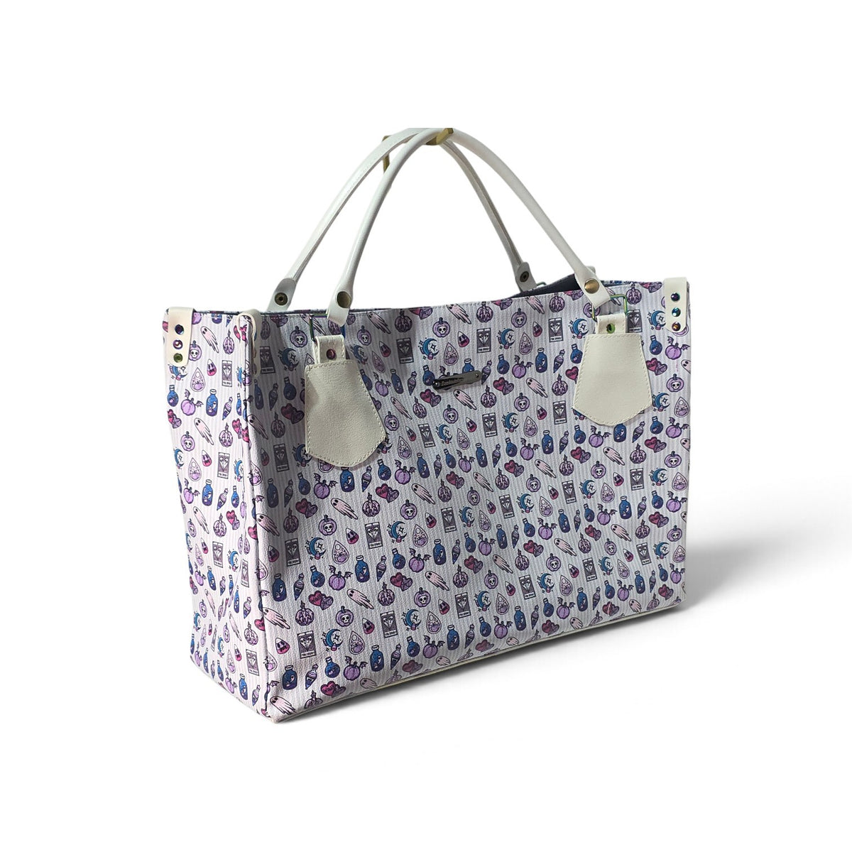A tote bag with a light purple and white patterned body featuring small illustrated motifs, off-white handles, and off-white leather-like hanging tags, photographed on a clean white background.