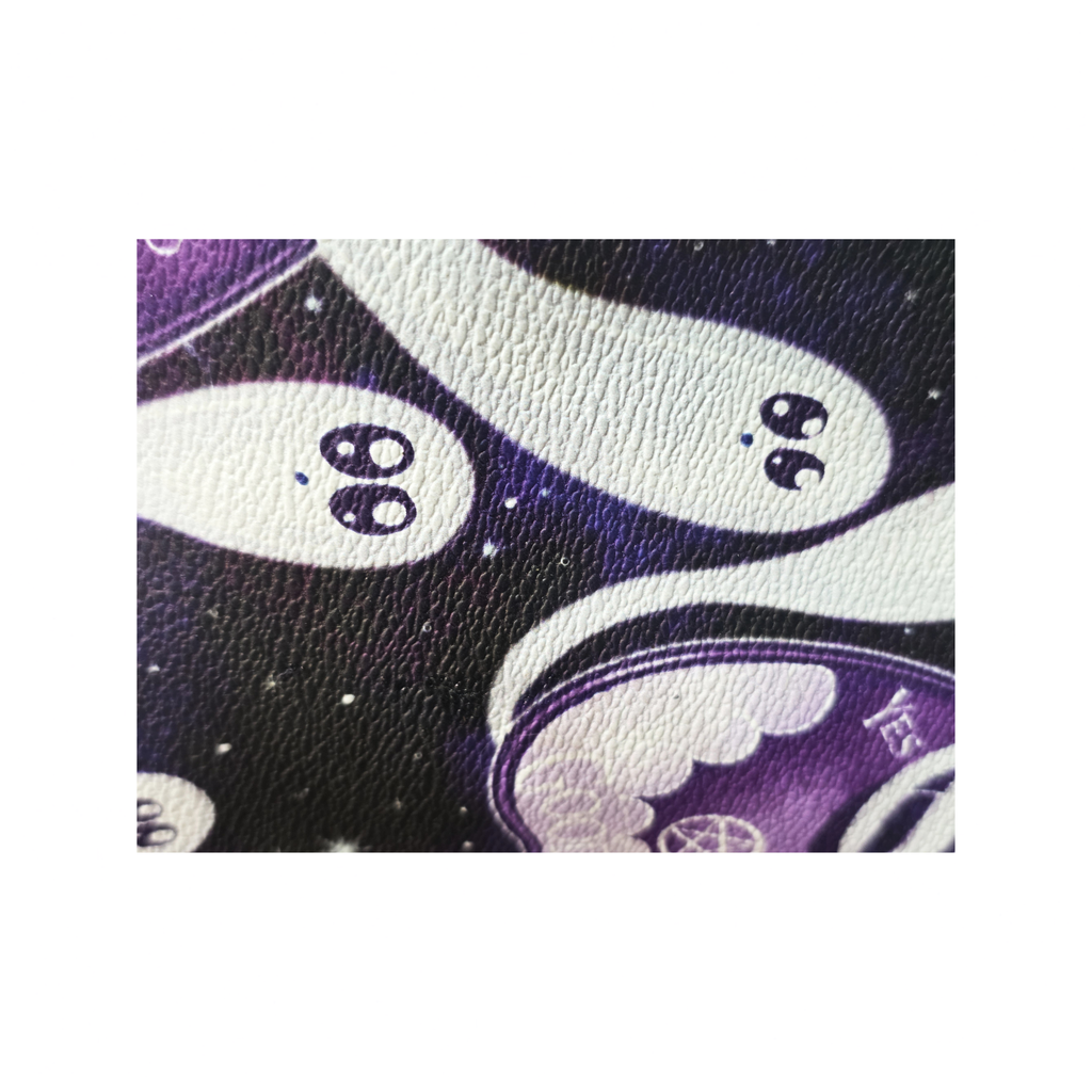 A close-up of a textured material featuring a cute cartoon ghost pattern on a dark purple and black starry background.