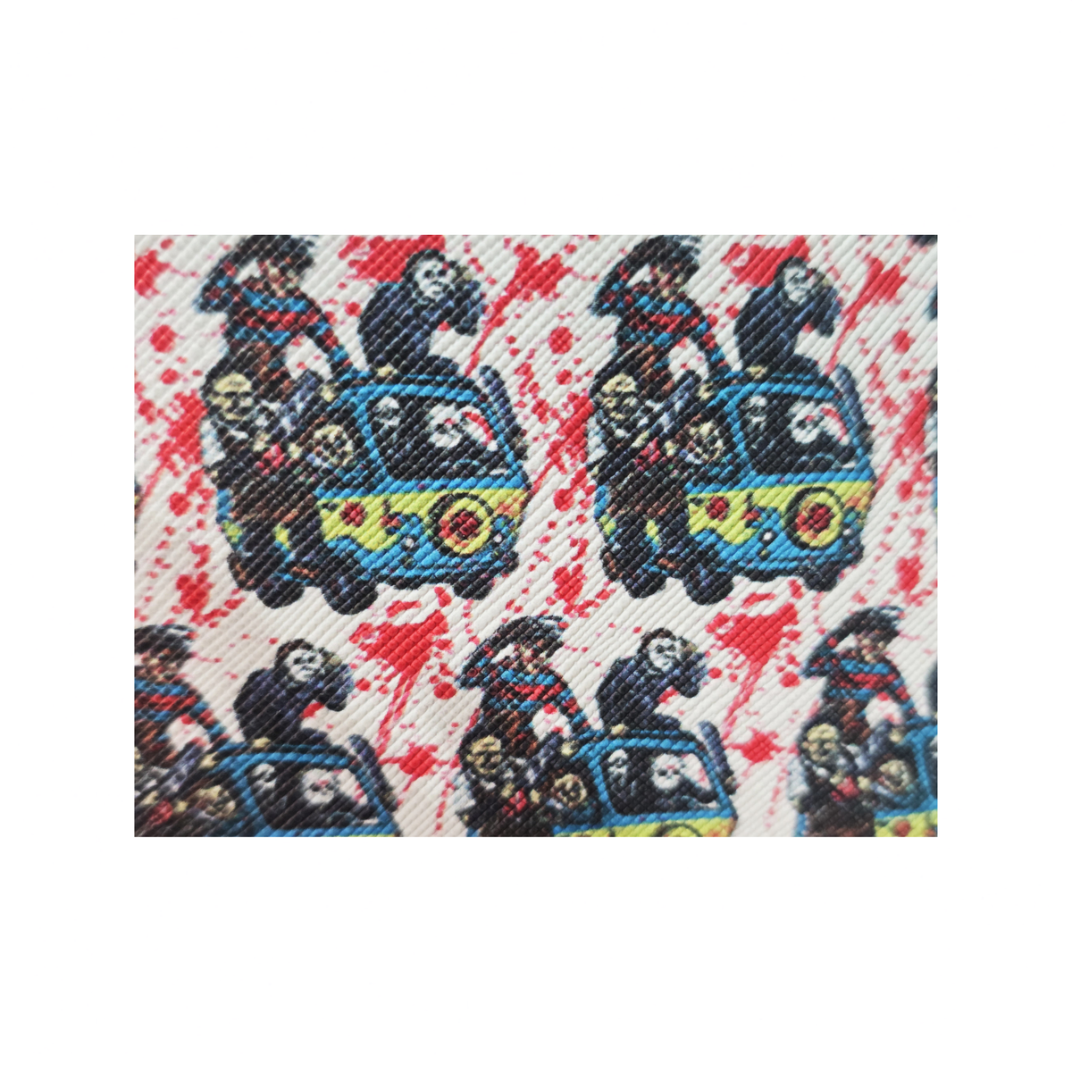 A close-up of a woven textile pattern featuring cartoon characters riding blue cars, with red splatter details on a light background.