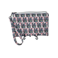 A wristlet clutch bag with a repeating pattern of vintage steam locomotives in blue, red, yellow, and green on a white background. The bag has a top zipper closure and a matching printed wrist strap, displayed on a small black stand against a plain white background.