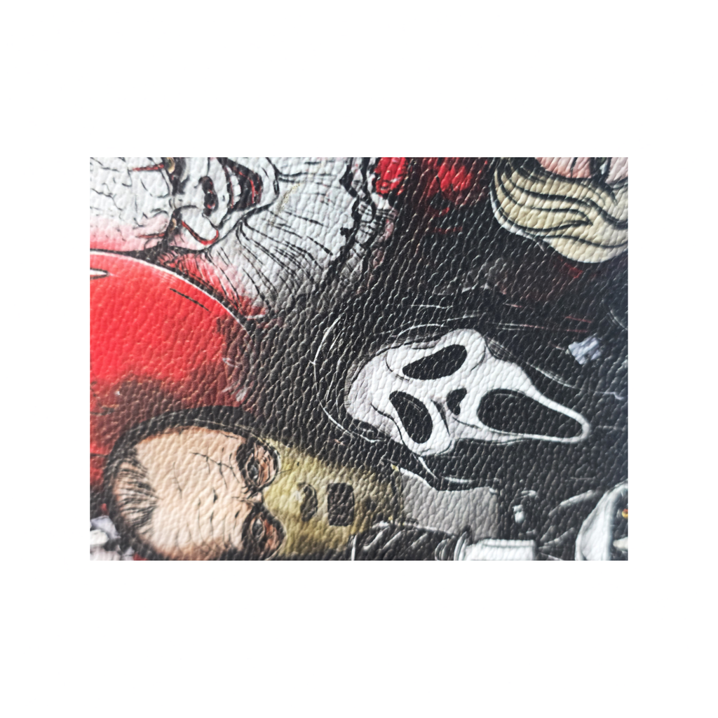 A close-up of a textured leather surface featuring a horror-themed collage print with stylized faces and the Ghostface mask in black, red, white, and beige tones.